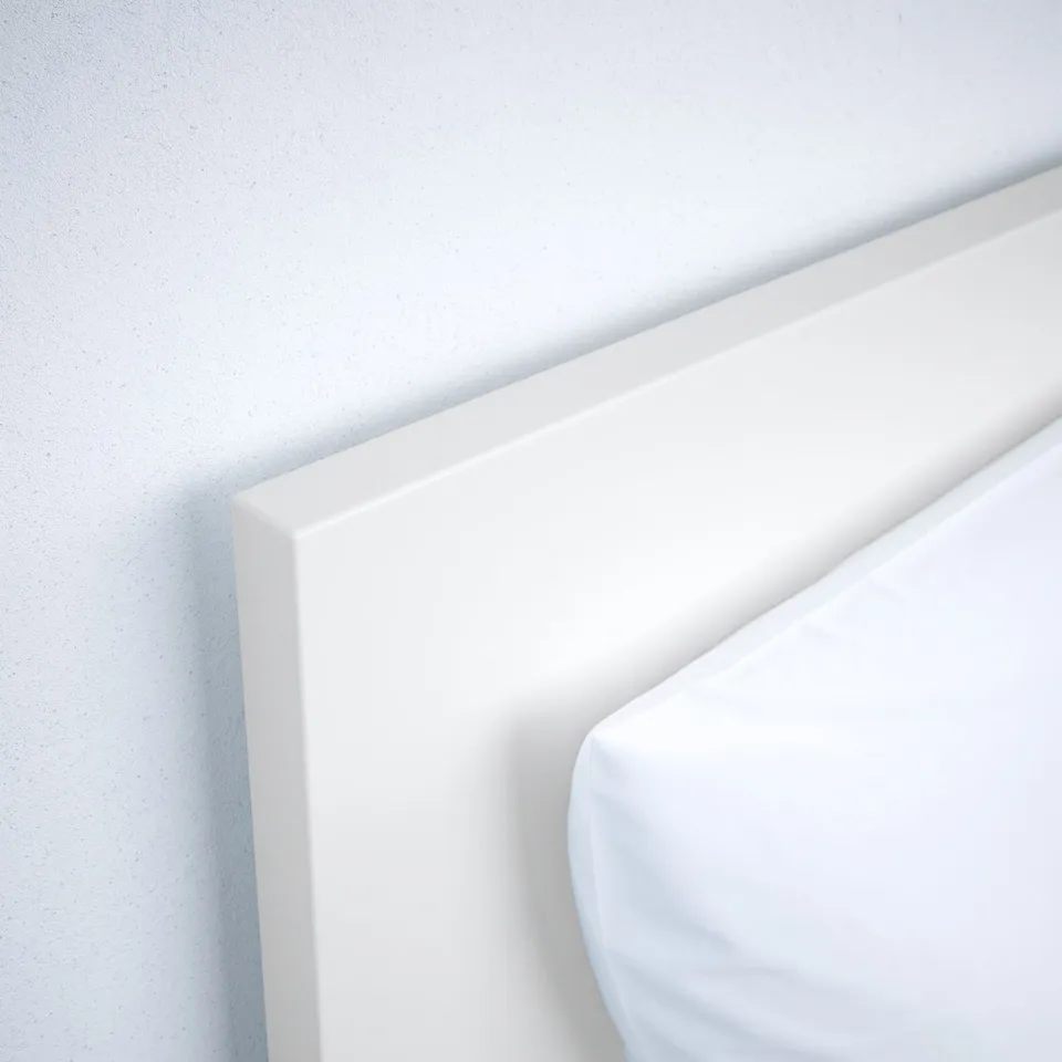 Smooth, white, modern bed frame. Clean lines, high headboard. High-quality finish and materials.