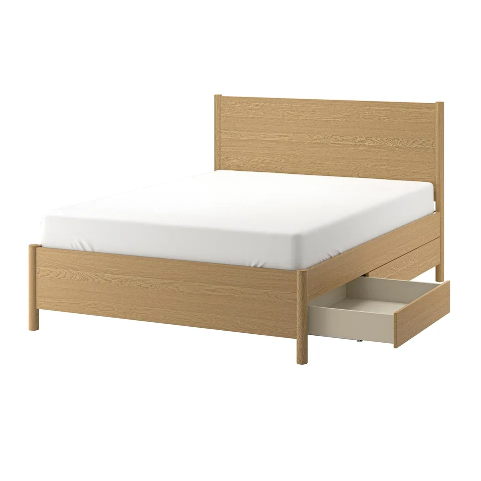 A TONSTAD light brown wooden bed with a white mattress and a drawer for storage.