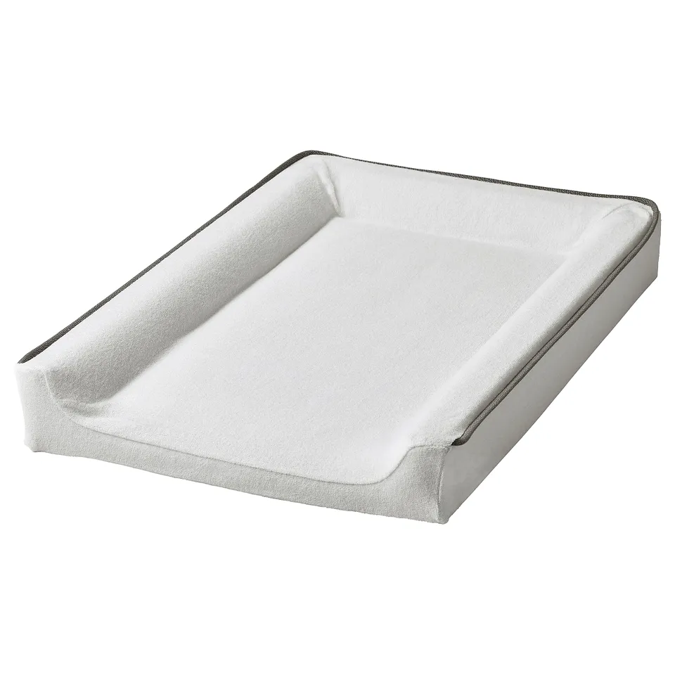 A VÄDRA white baby changing mat cover. Rounded edges, soft terry cloth material, designed to fit VÄDRA mat.