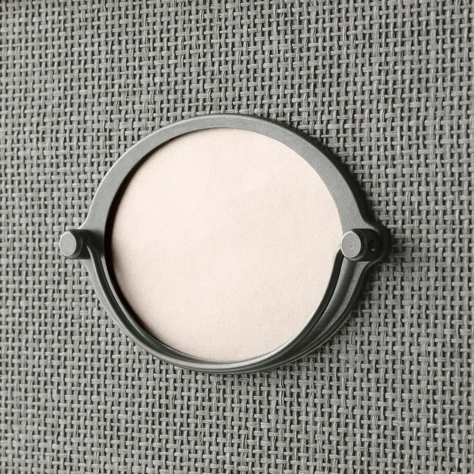 A chic, round box with woven paper exterior and a handle. Perfect for storage, with a stylish design.