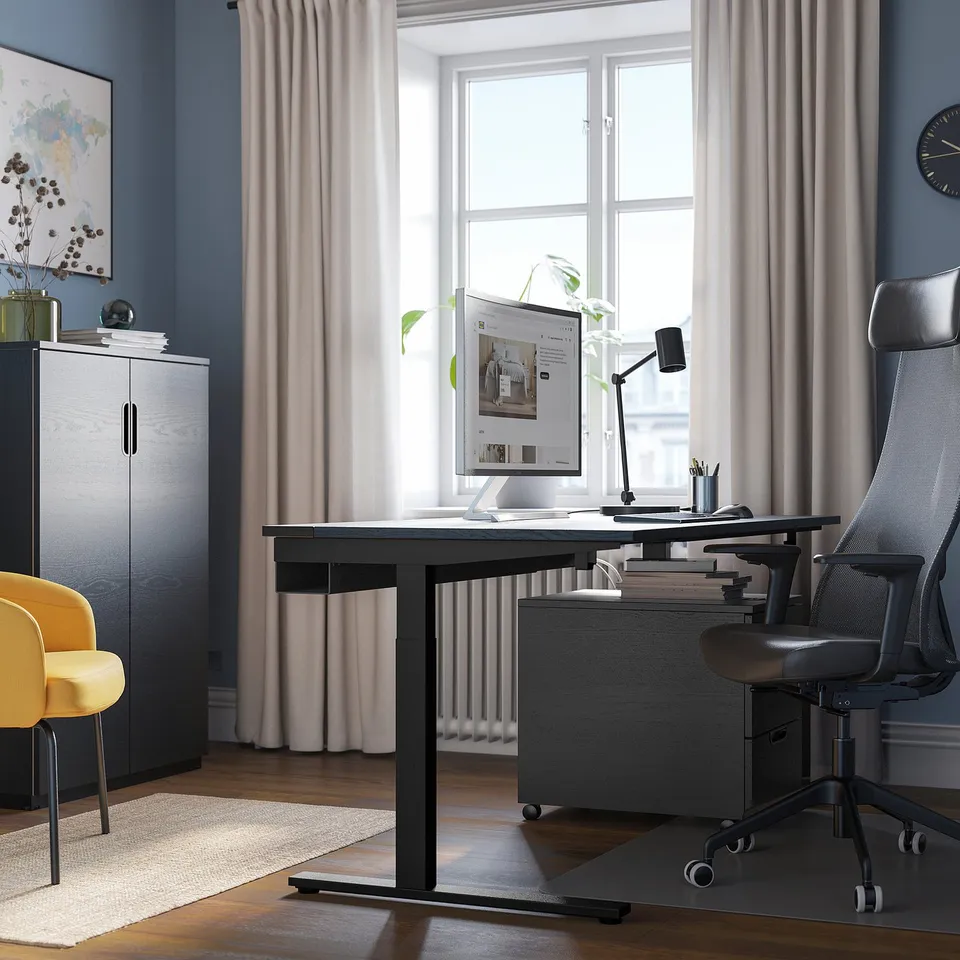 Home office: MITTZON desk, grey chair, window, yellow accent, storage with plant & map.