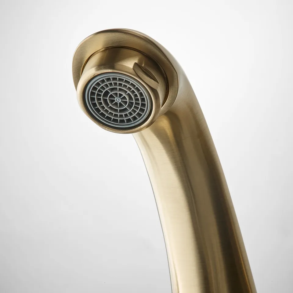 Golden tap closeup, sleek design, brass material, circular water outlet.