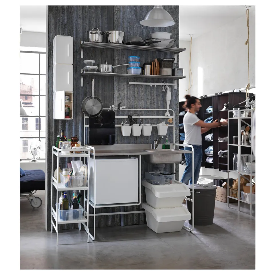 Small, white, portable kitchen setup with stainless steel counter, shelves, and appliances. Suitable for compact spaces.