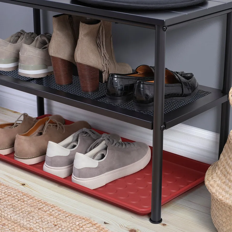 Shoe rack with metal shelves, featuring red mat under lower shelf for floor protection from dirt and water.