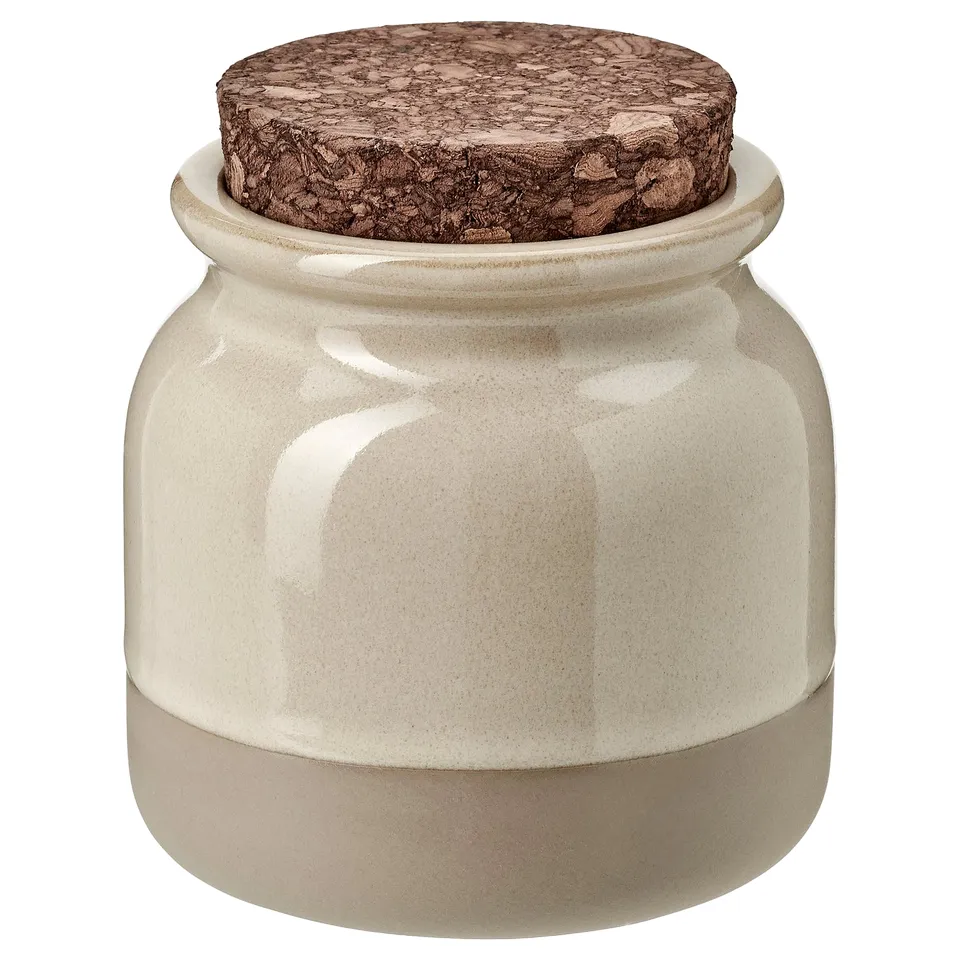 A BRUGDHAJ jar in light colour with a cork lid, made of stoneware, designed for kitchen storage.