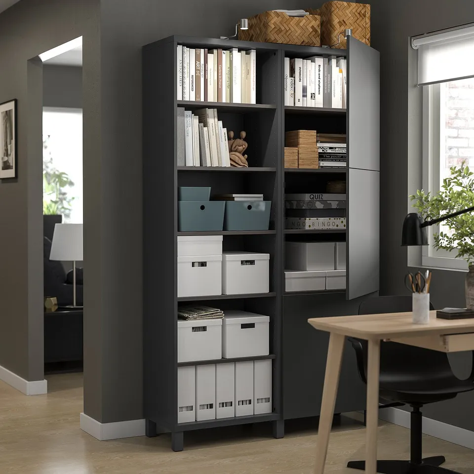 Dark grey BESTÅ bookshelf with open & closed storage, adjustable shelves, displaying books, hiding items in home office.