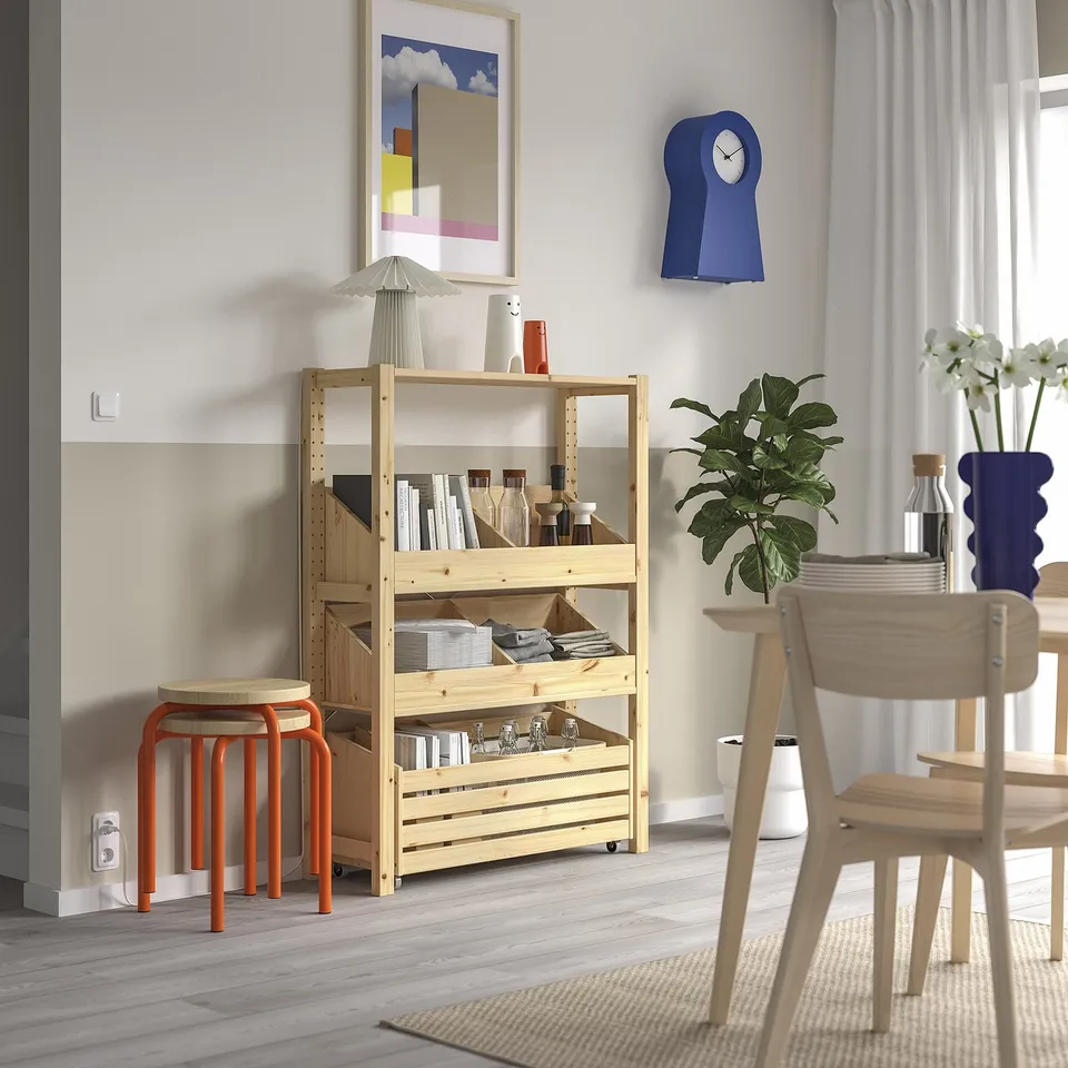 Modern living room with IVAR storage, artwork, and plants.