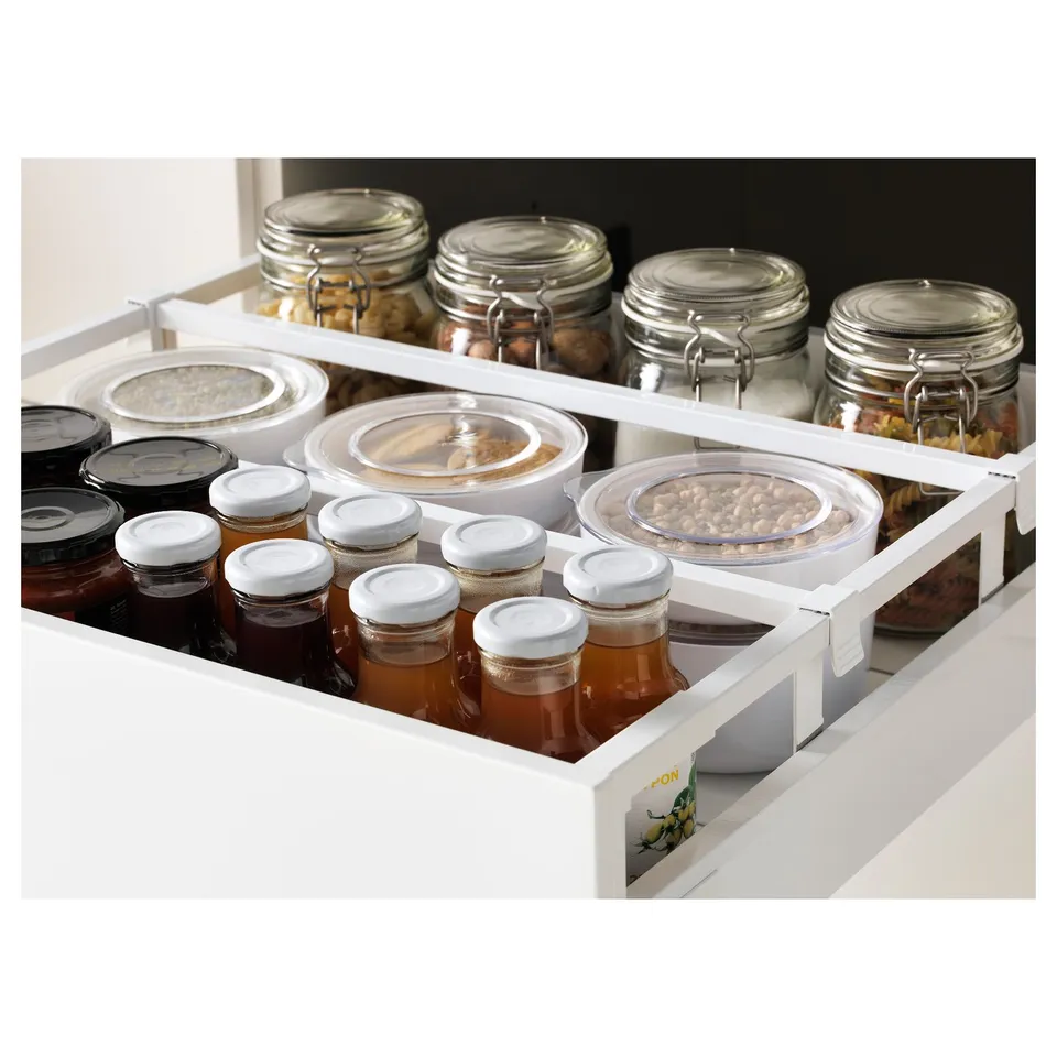 White kitchen drawer with jars and containers. Includes glass jars with white lids and plastic food containers.