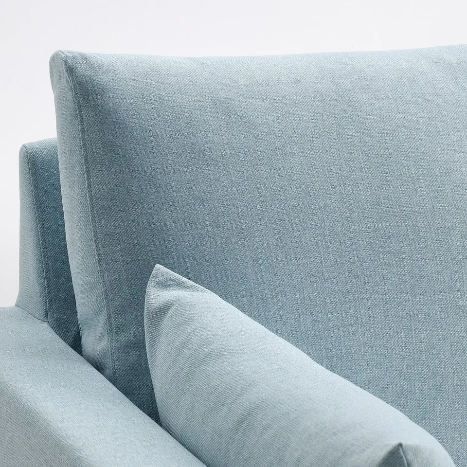 Light blue sofa, upholstered in textured fabric, designed for comfort with plush cushions, offering a cosy and inviting appearance.