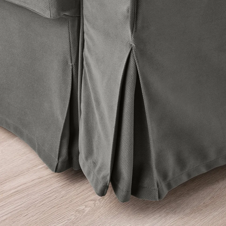 Close-up of grey sofa-bed corner, showing smooth texture and durable fabric.