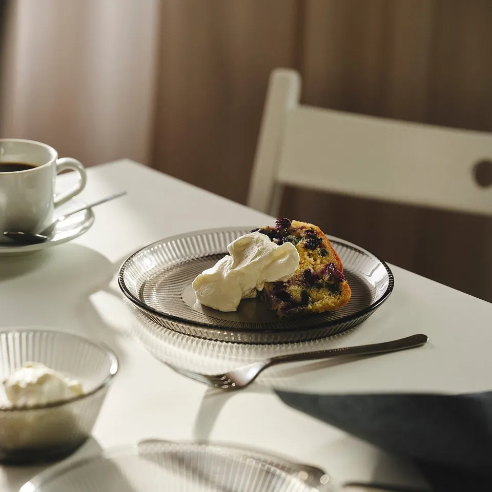 Dessert plate with cake, whipped cream, coffee, and glassware.