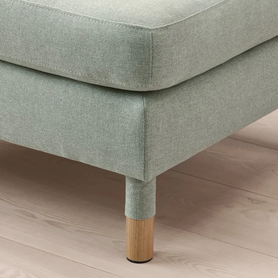 Grey cushioned footstool with wooden legs & quality upholstery.