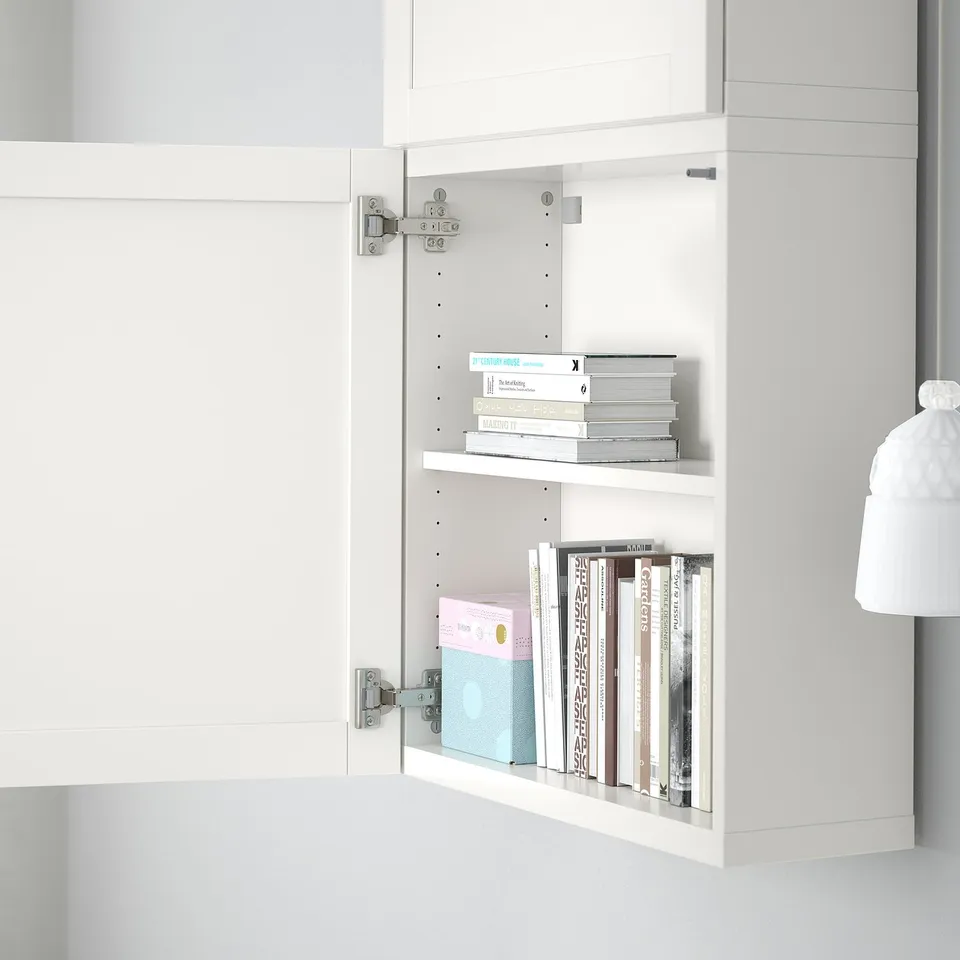 Open white cabinet with adjustable shelves holding various books, showing customizable storage.