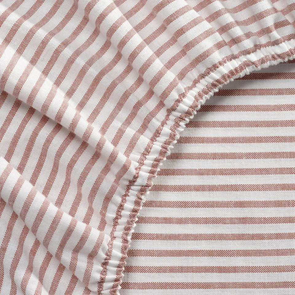 Striped bed sheet, close-up; crisp white and reddish-brown stripes, neat stitching, thick cotton texture.