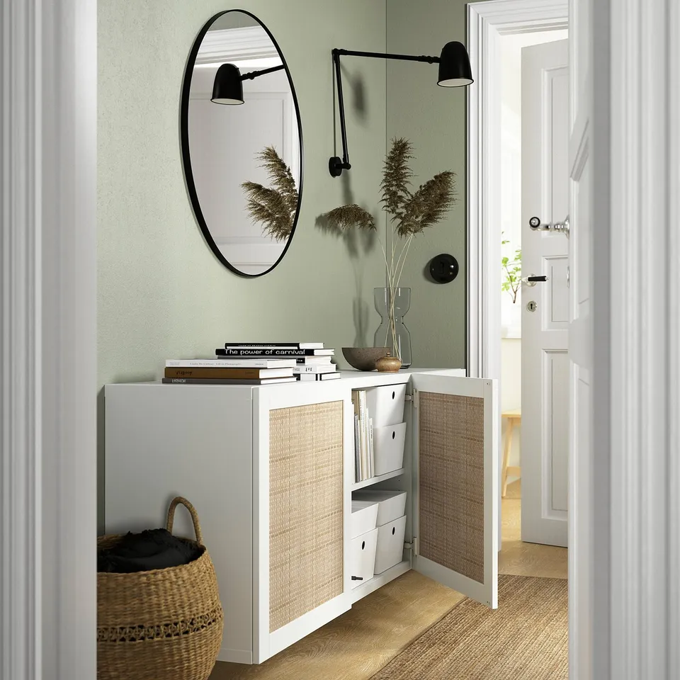 Hallway with white cabinet, woven doors, and wall lights.