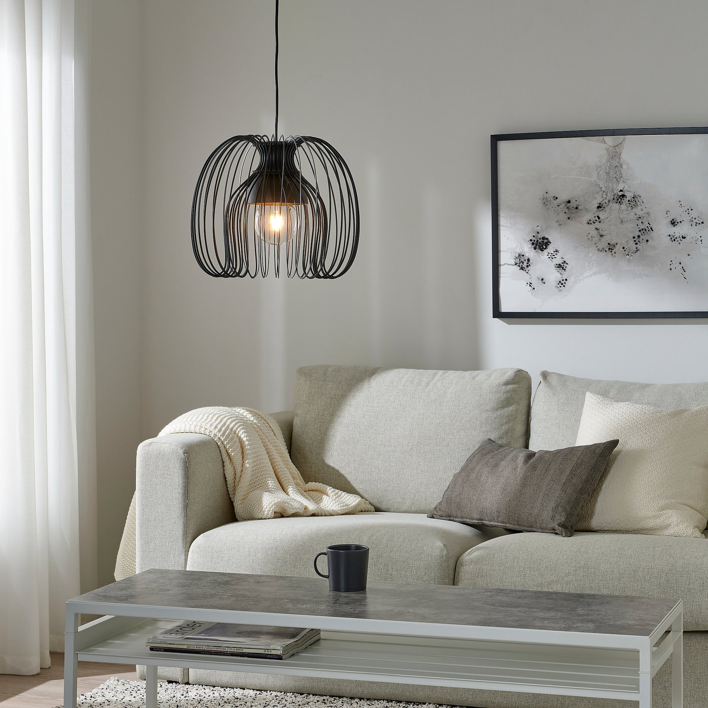 Modern living room with beige sofa, KALLFRONT lamp, grey coffee table, abstract art, minimalist decor.