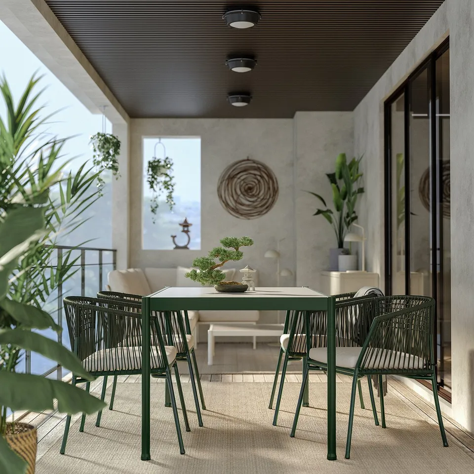 Modern patio: green metal table, 4 chairs, plastic weave seats, concrete walls, plants, glass door.