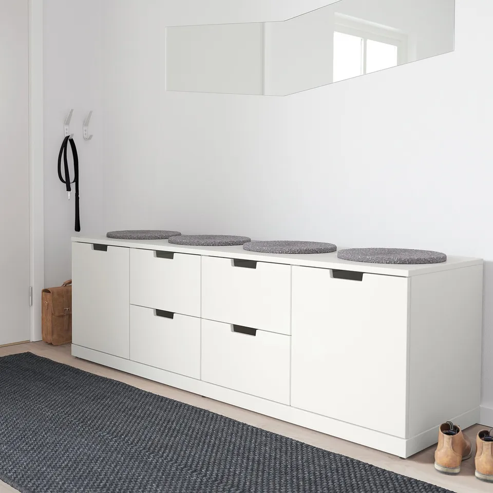 NORDLI chest with grey cushions, by door, large mirror, rug.