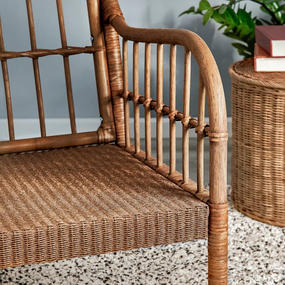 Rattan armchair close-up, showcasing intricate weaving and natural wood finish.