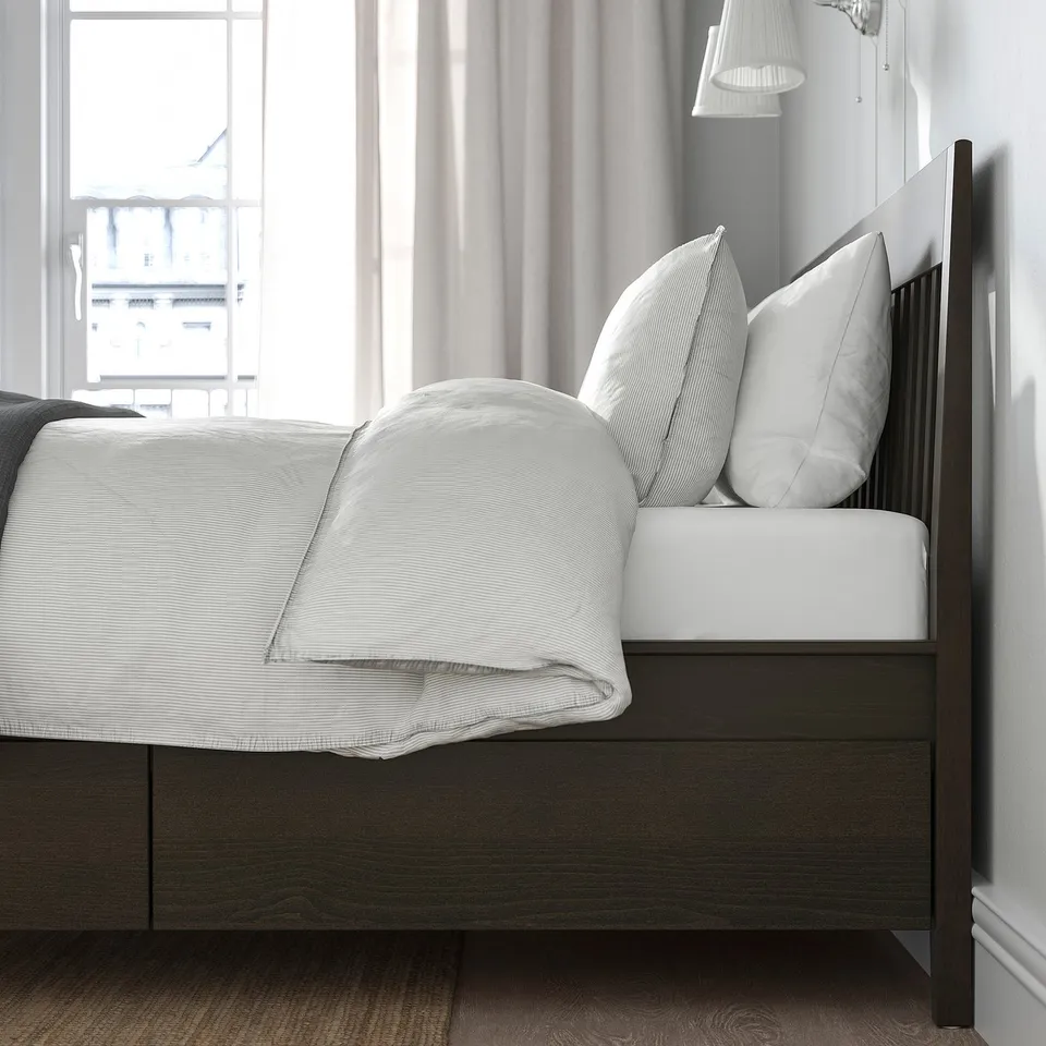 A modern bed frame with built-in drawers, soft-closing feature, and slatted base. Made from wood veneer, it provides practical storage.