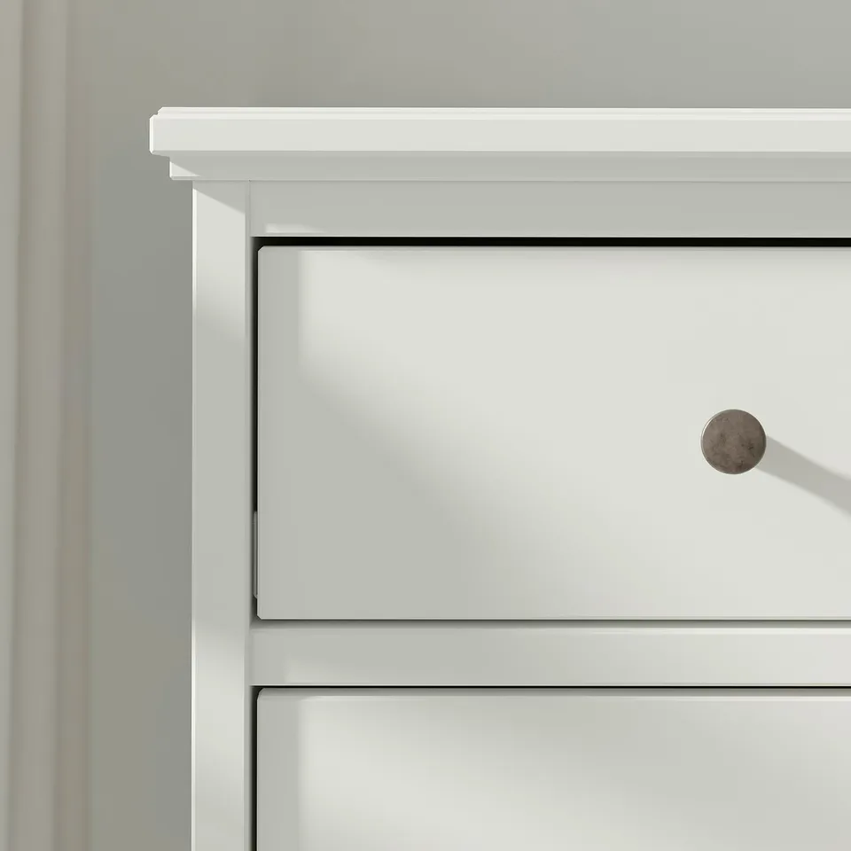 The IDANÄS chest of drawers in white has a sleek, modern design with smooth, flat surfaces and circular knobs.