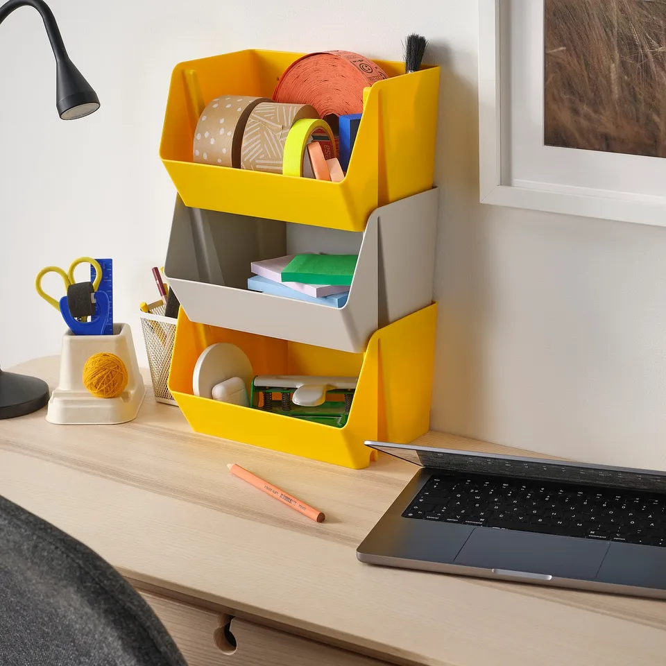 Yellow FODERTRÅG organiser stores craft supplies neatly next to a laptop on a wooden desk.