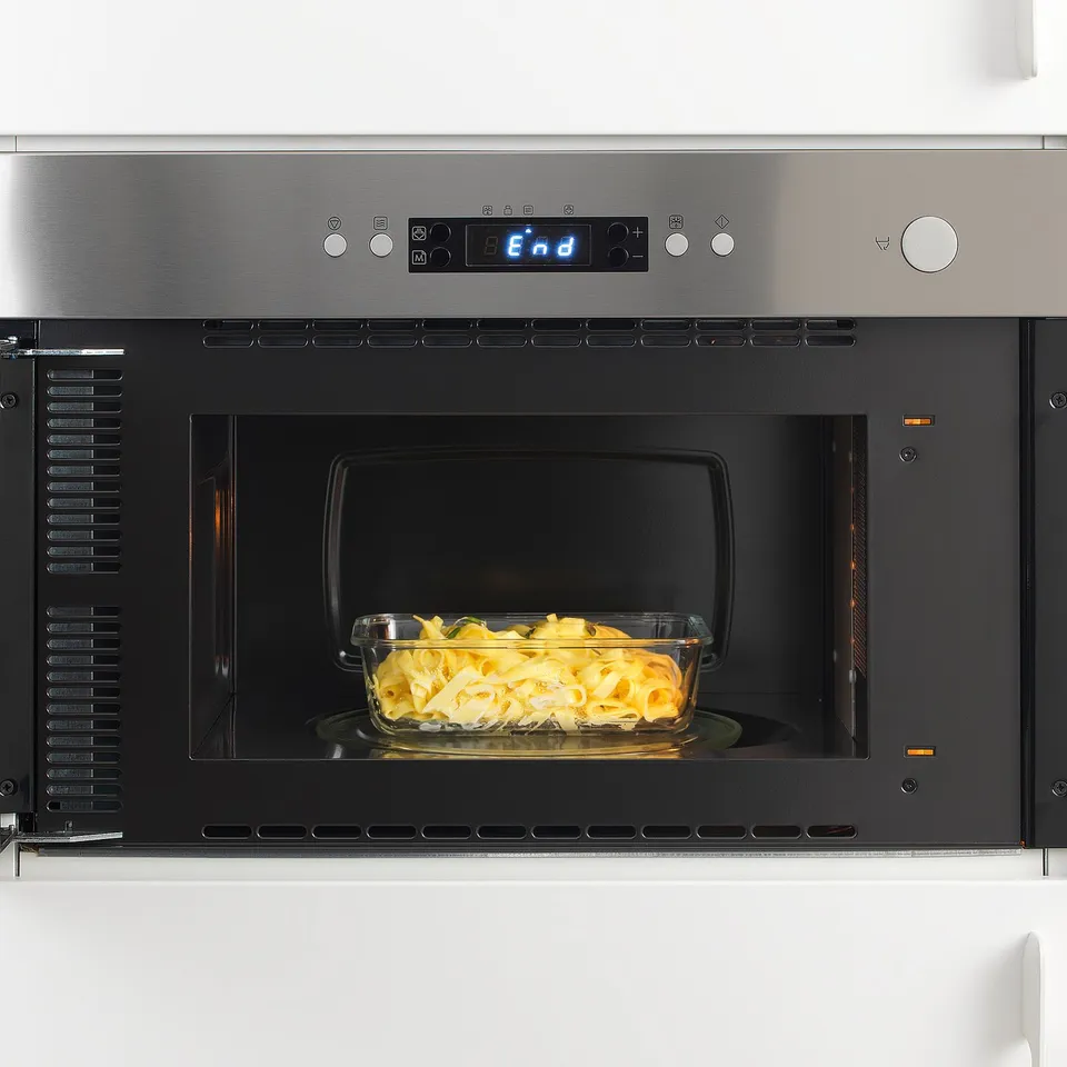Built-in microwave with glass bowl inside, showing reheating functionality. Digital display indicates end, suggesting cooking is complete.
