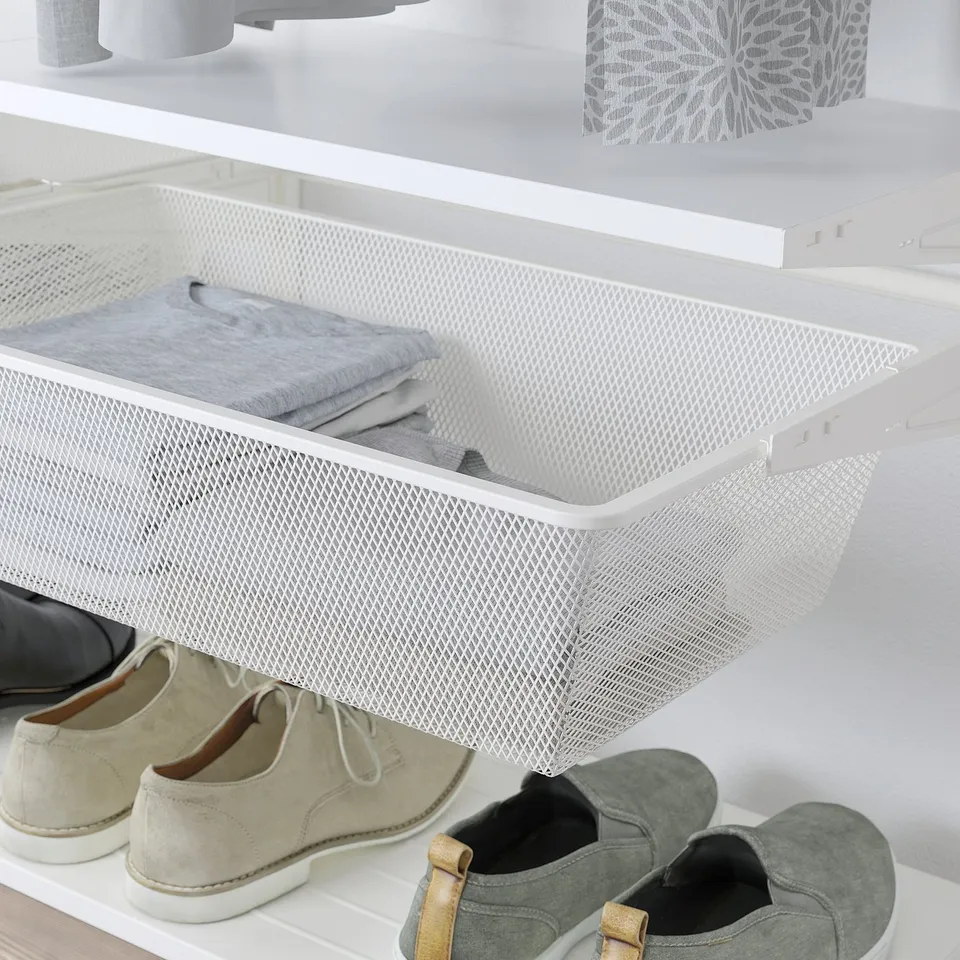 White mesh storage drawer holds folded clothes, mounted inside closet, keeps small items organised.