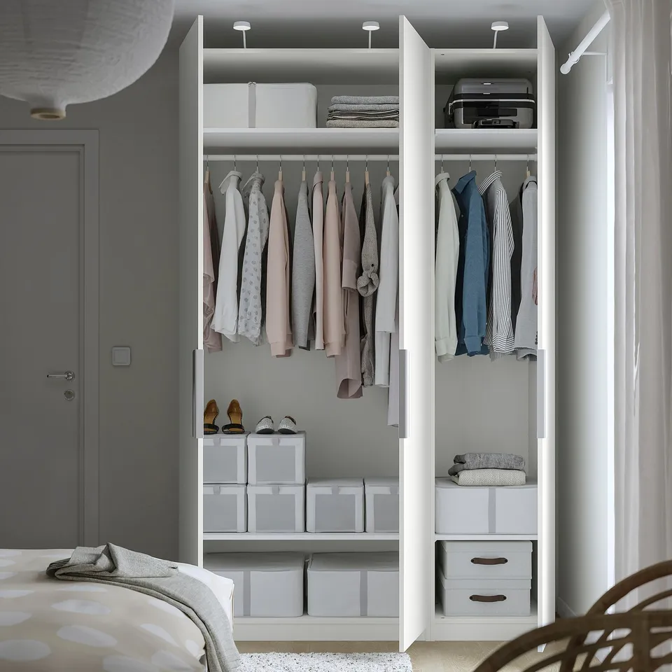 Open wardrobe with clothes hangers, shelves, and storage boxes; integrated lighting.