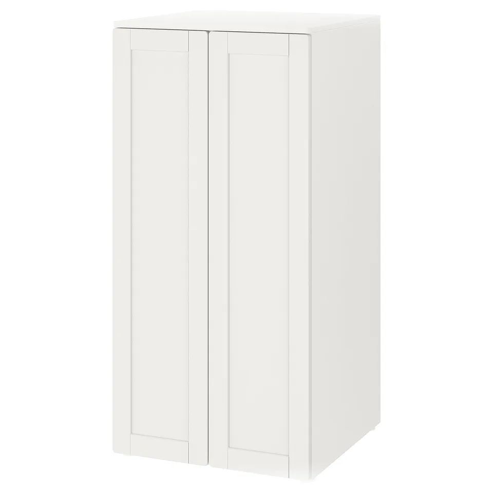 A white SMÅSTAD storage cabinet with two doors. It stands upright, made from fibreboard and particleboard, designed for storing childrens items.