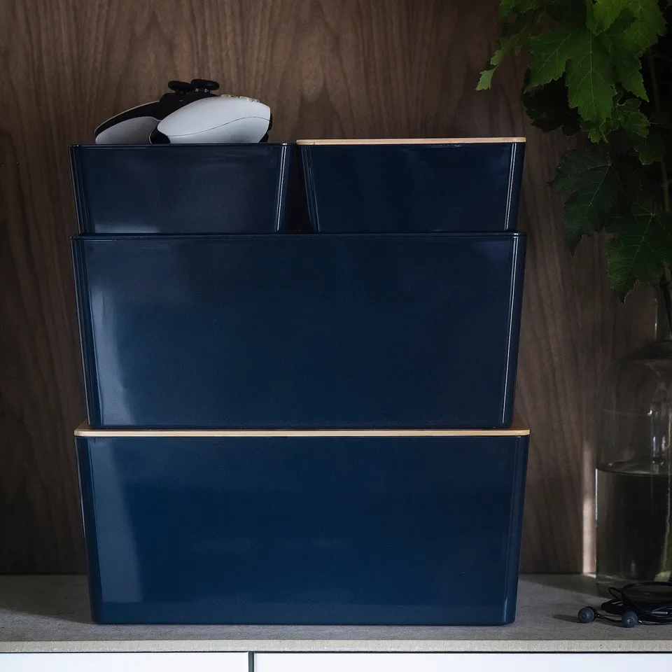 Stacked navy blue boxes with lid, perfect for organising gadgets. Top box holds a mouse. Ideal for desks and stacking.