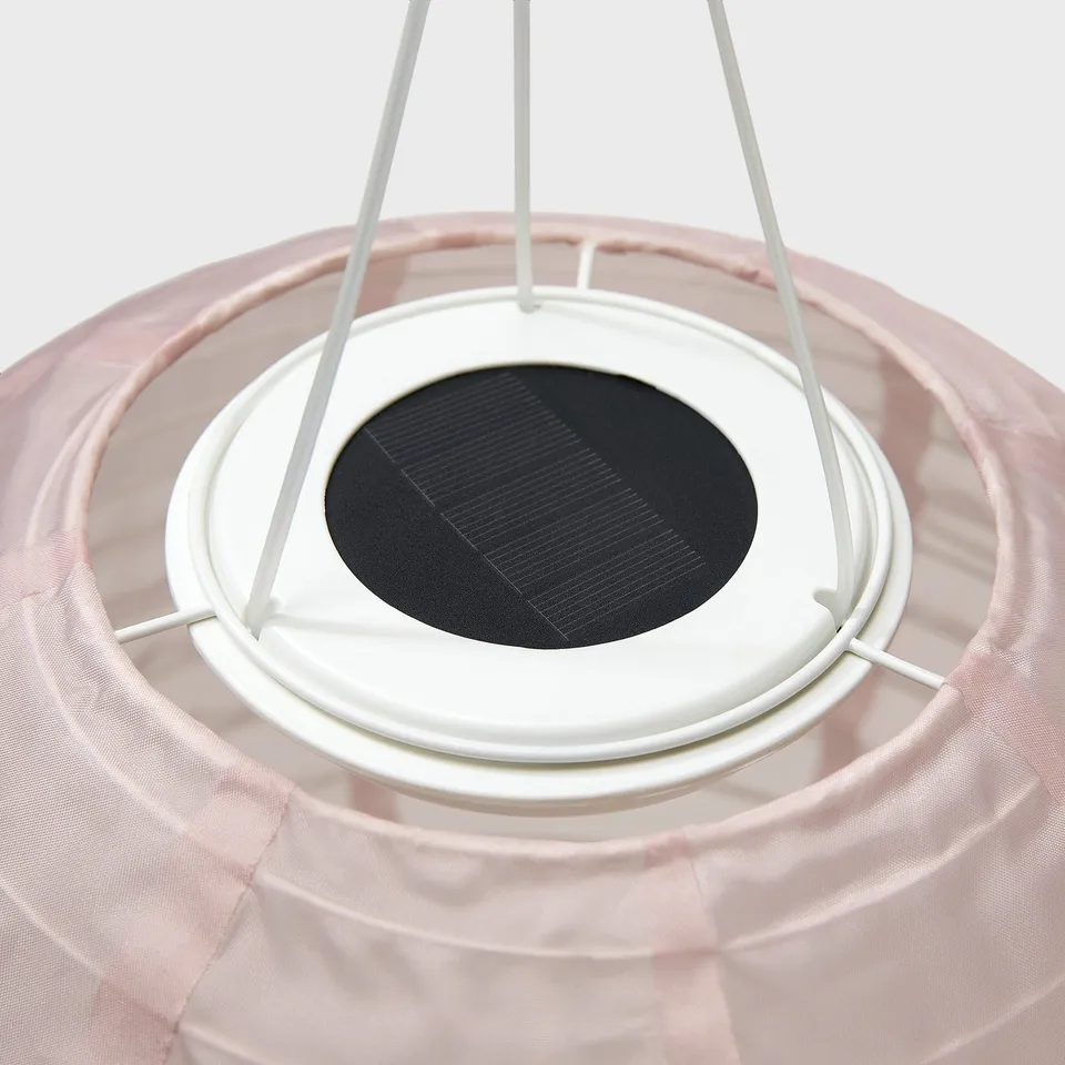 Solar-powered pendant lamp with white frame and light pink shade, made from recycled materials.