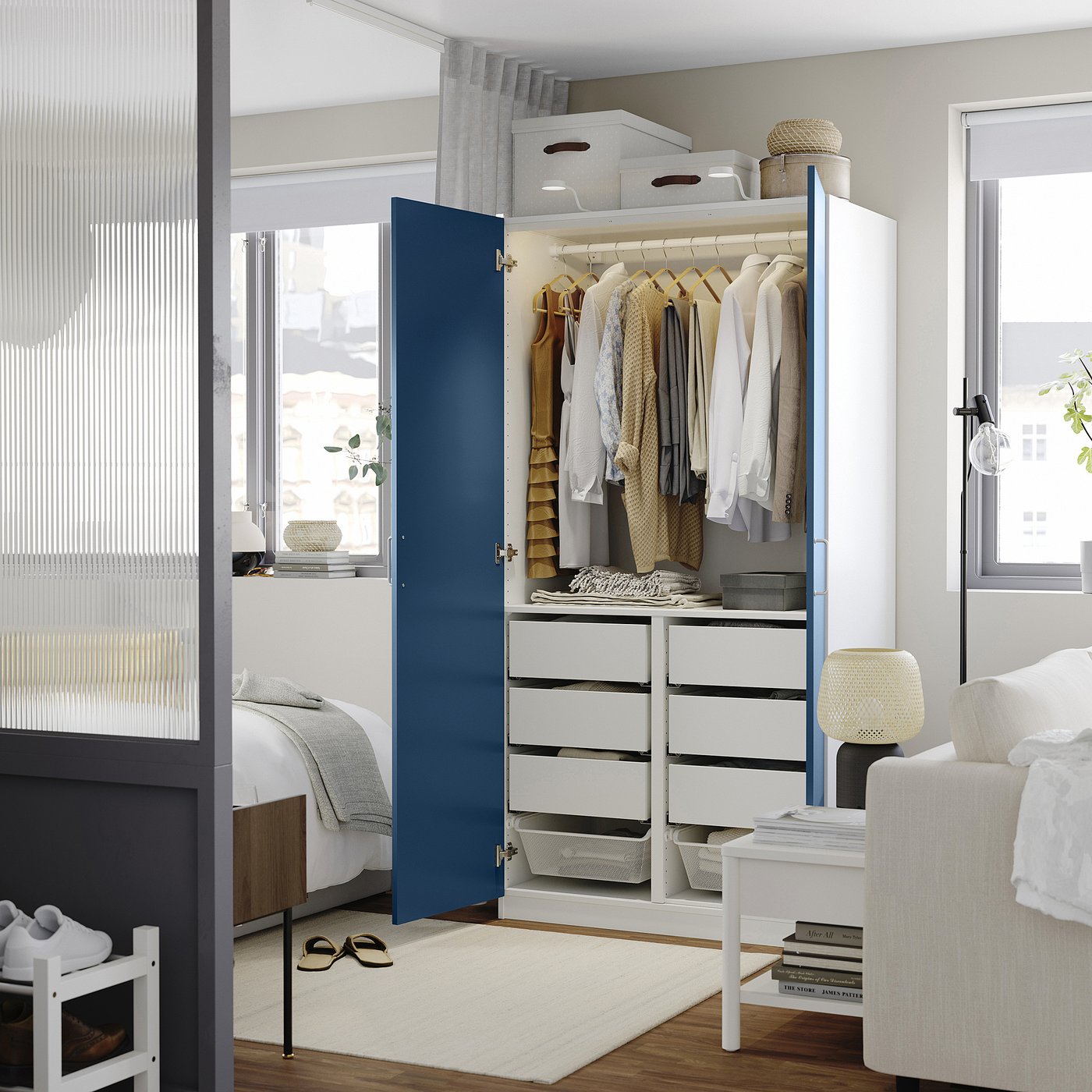 Modern bedroom with white & blue modular wardrobe and storage.