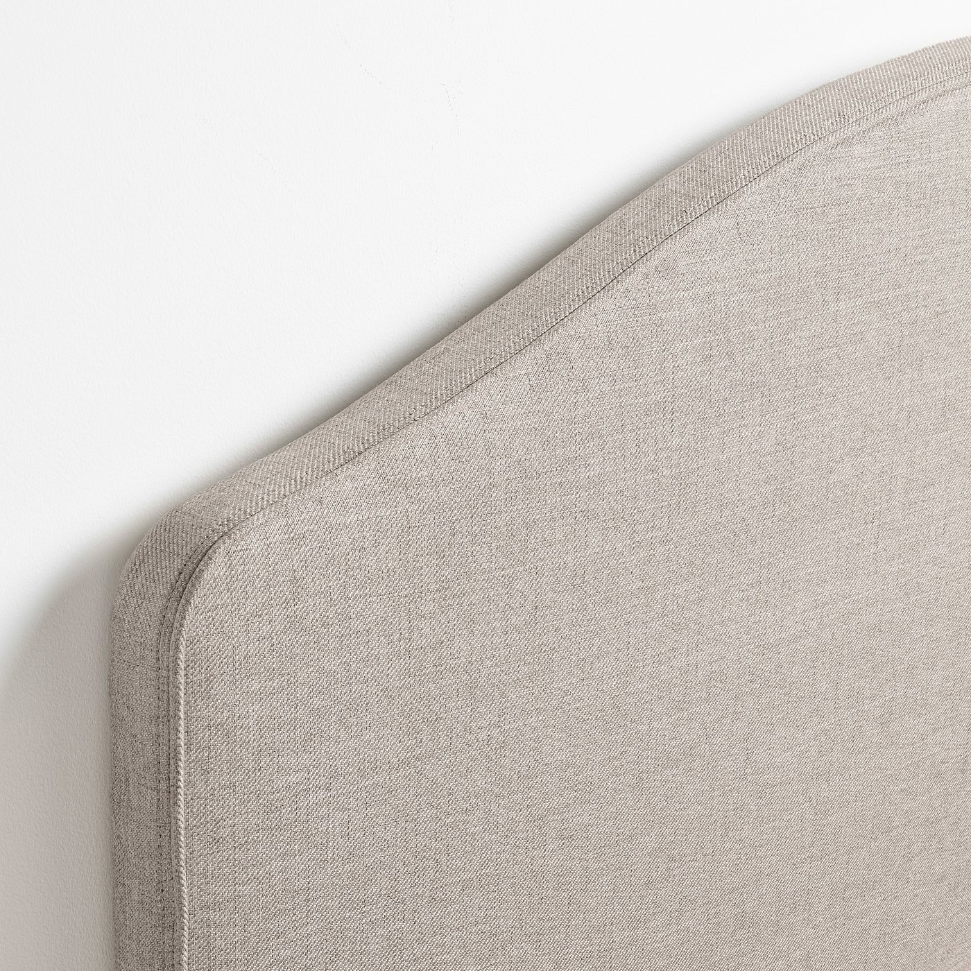 Soft, beige upholstered bed corner with neat stitching, part of ramnefjall bed frame.