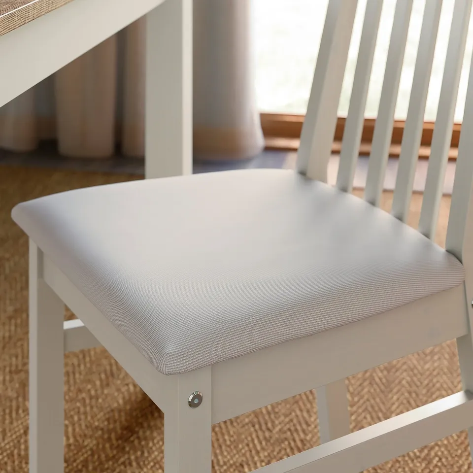 Close-up of a stylish, cushioned ÅLHULT chair, showing its soft seat, sturdy pine frame, and quality upholstery.