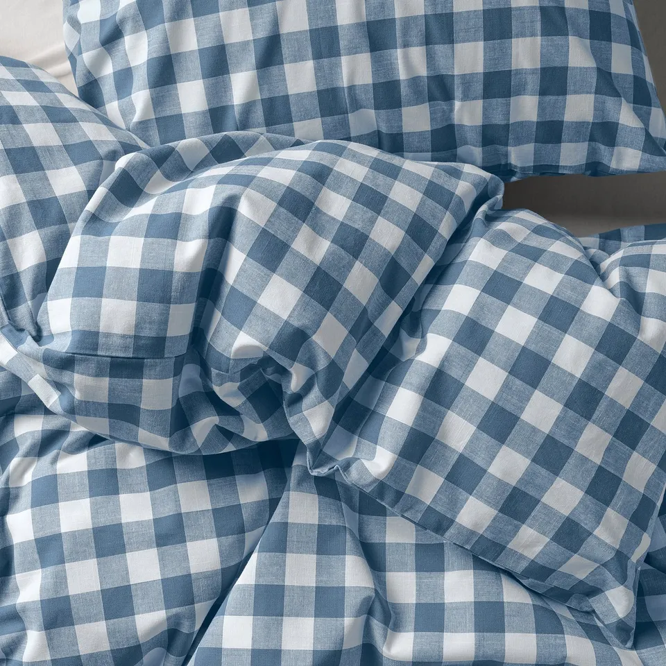 Chequered blue and white duvet covers, neatly arranged. Soft, breathable organic cotton.