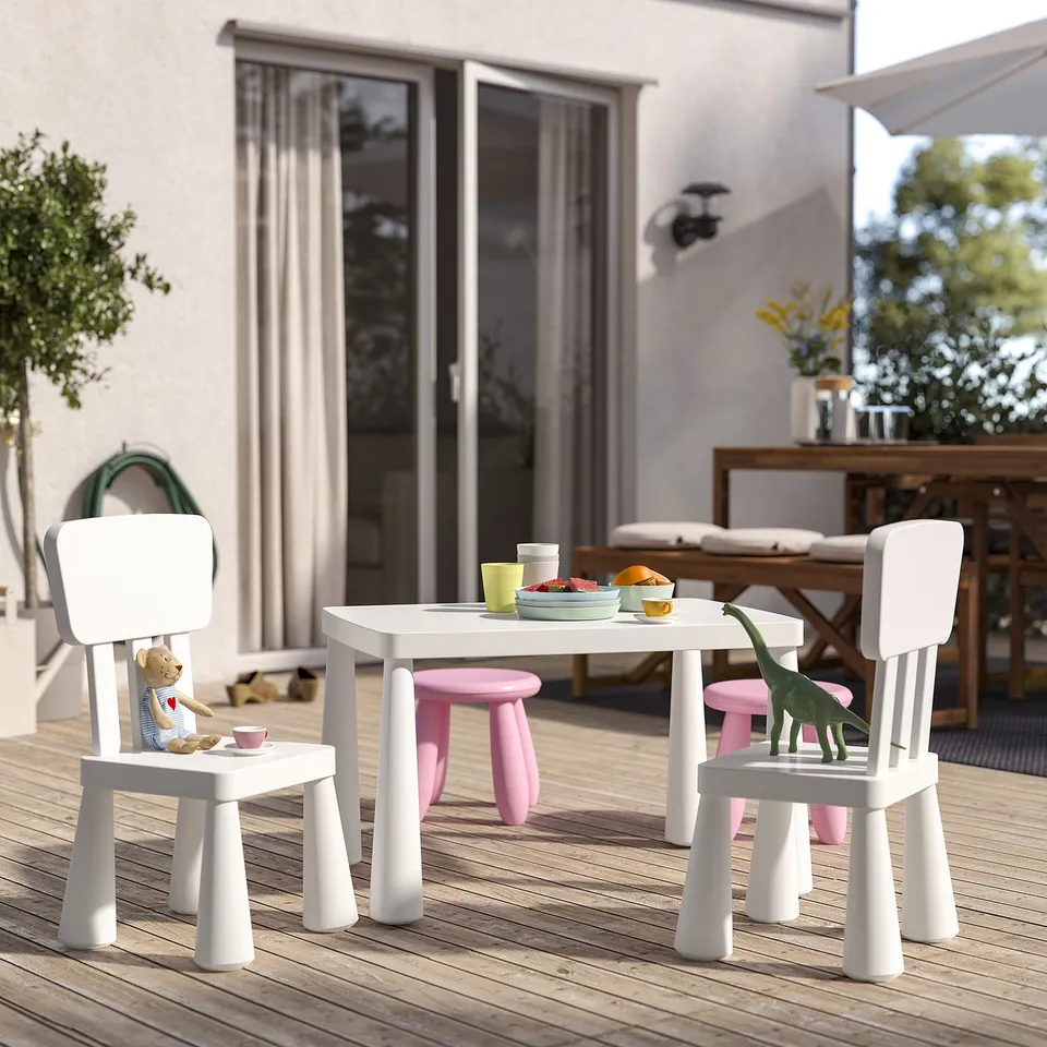 Small, white MAMMUT childrens table set on patio, with two chairs and toys, designed for durability and outdoor use.