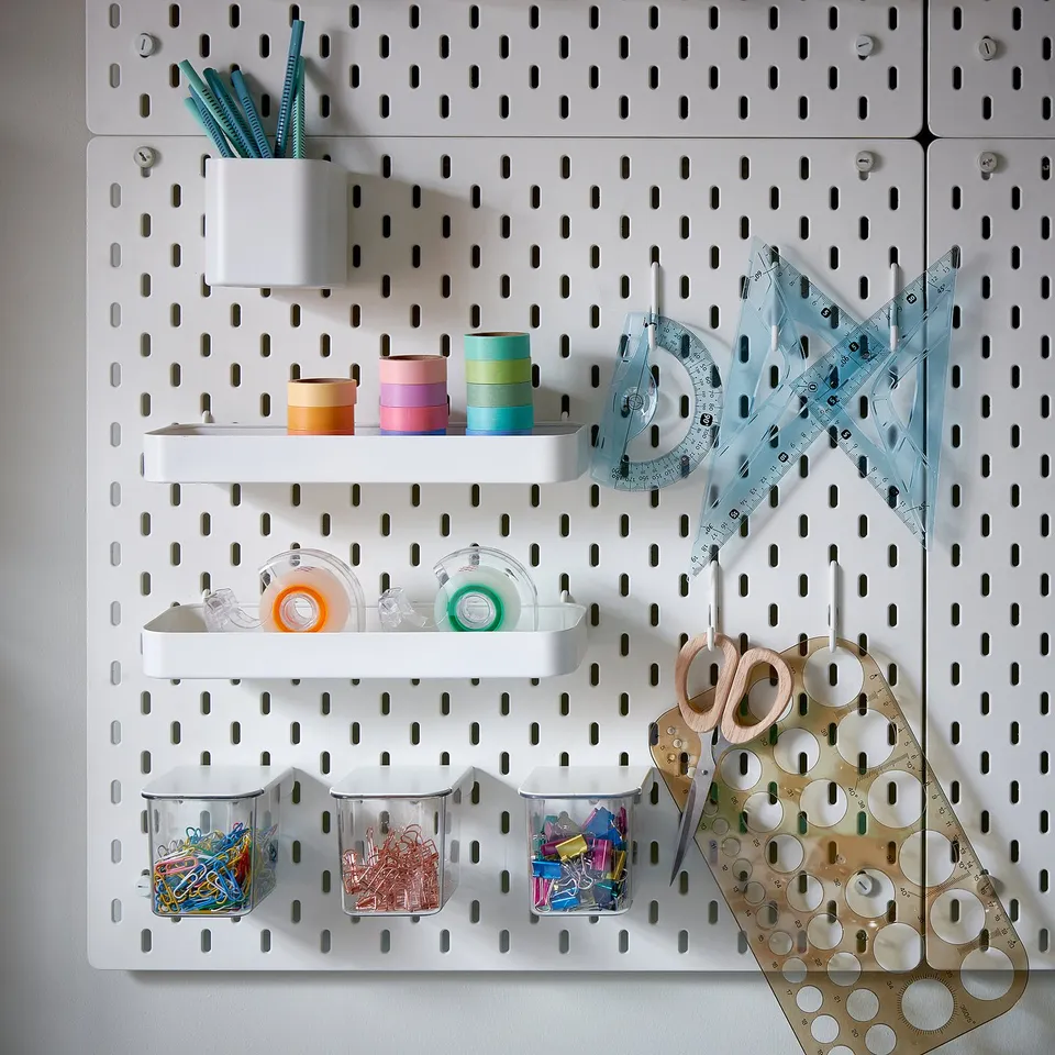 SKÅDIS white pegboard organiser with colourful office supplies, containers, and rulers.