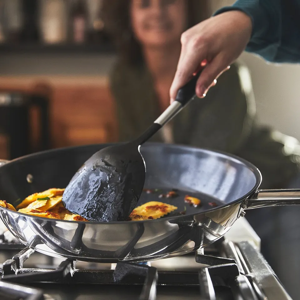 Cooking with non-stick frying pan on gas stove.