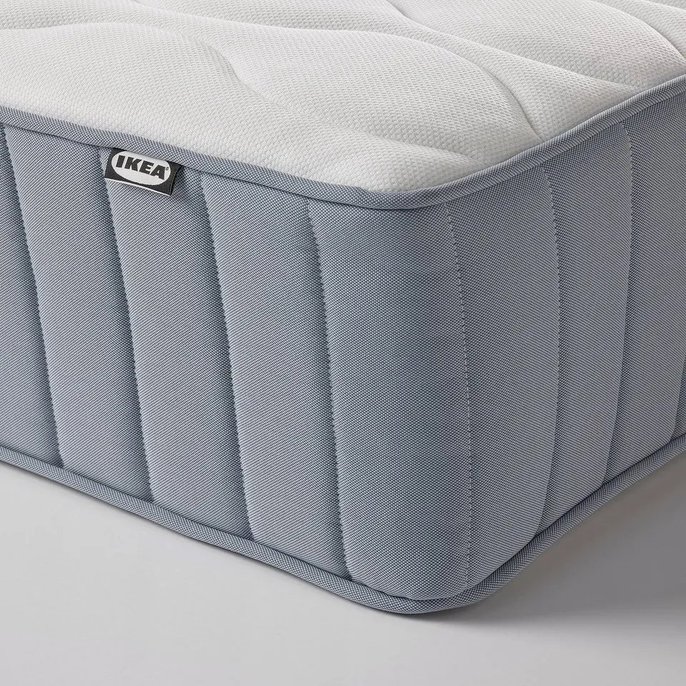 Close-up of ikea mattress, showcasing soft, quilted texture and edge stitching, highlighting quality and comfort.