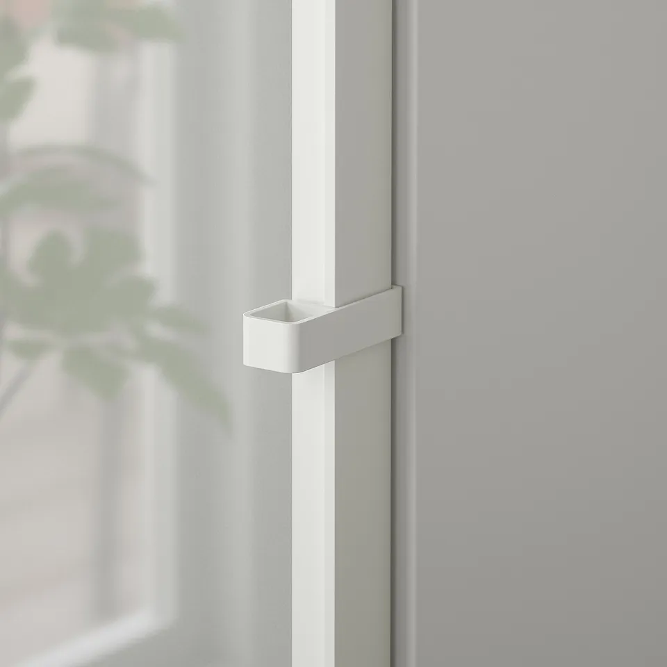 Close-up of a modern, sleek white door handle on a glass door, emphasising its clean design and high-quality metallic finish.
