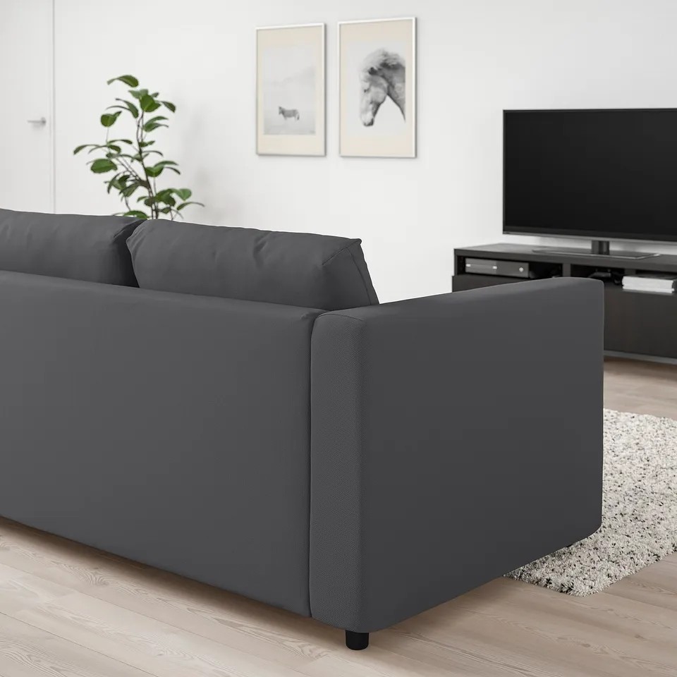 Modern living room with large grey VIMLE sofa, tv, plant, & minimalist decor. Sofa is well-cushioned & matches room size.