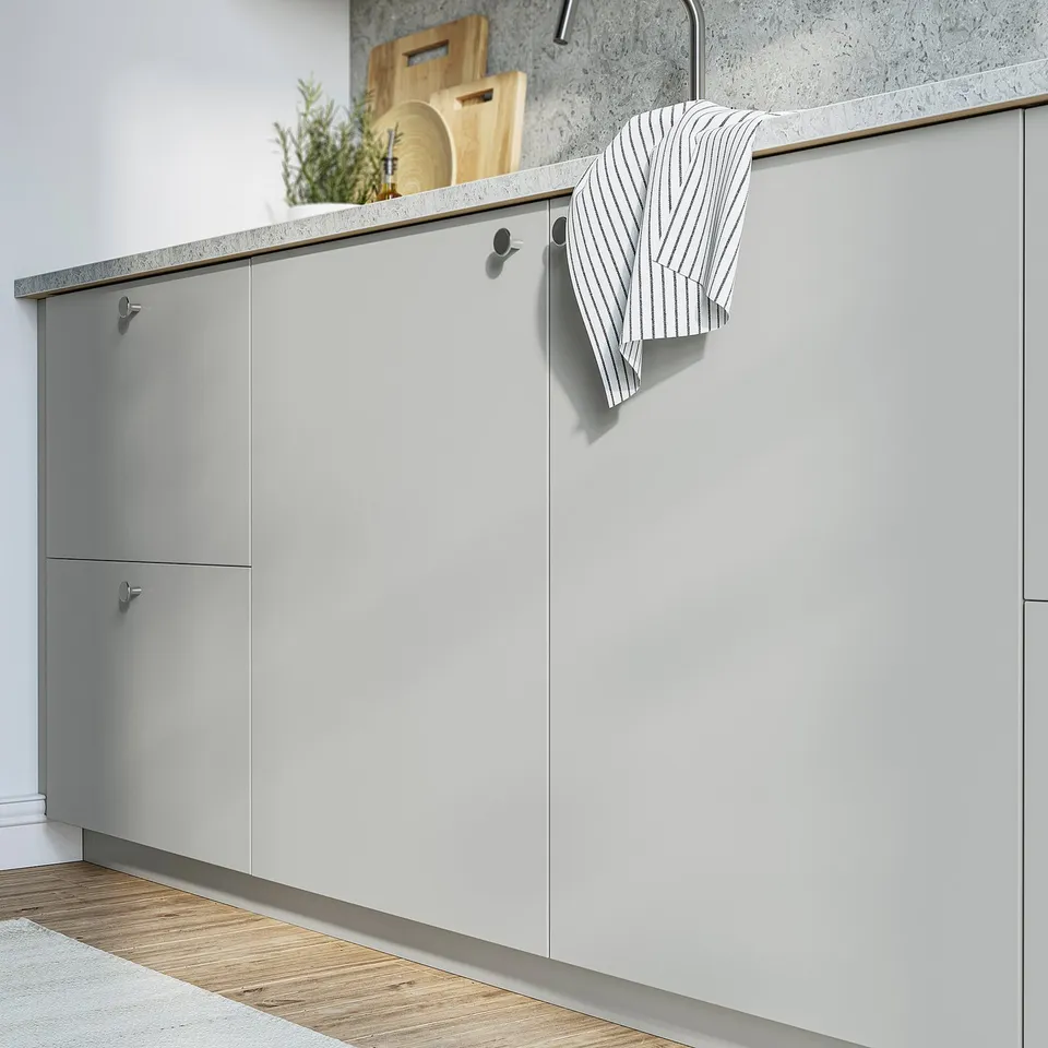 Modern kitchen with grey HAVSTORP cabinets, striped towel, cutting boards, and plant.