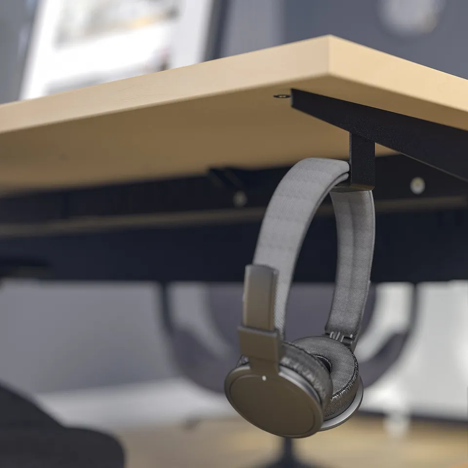 Headphones hang on desk hook. Desk is height-adjustable, sturdy, and includes cable management tray.