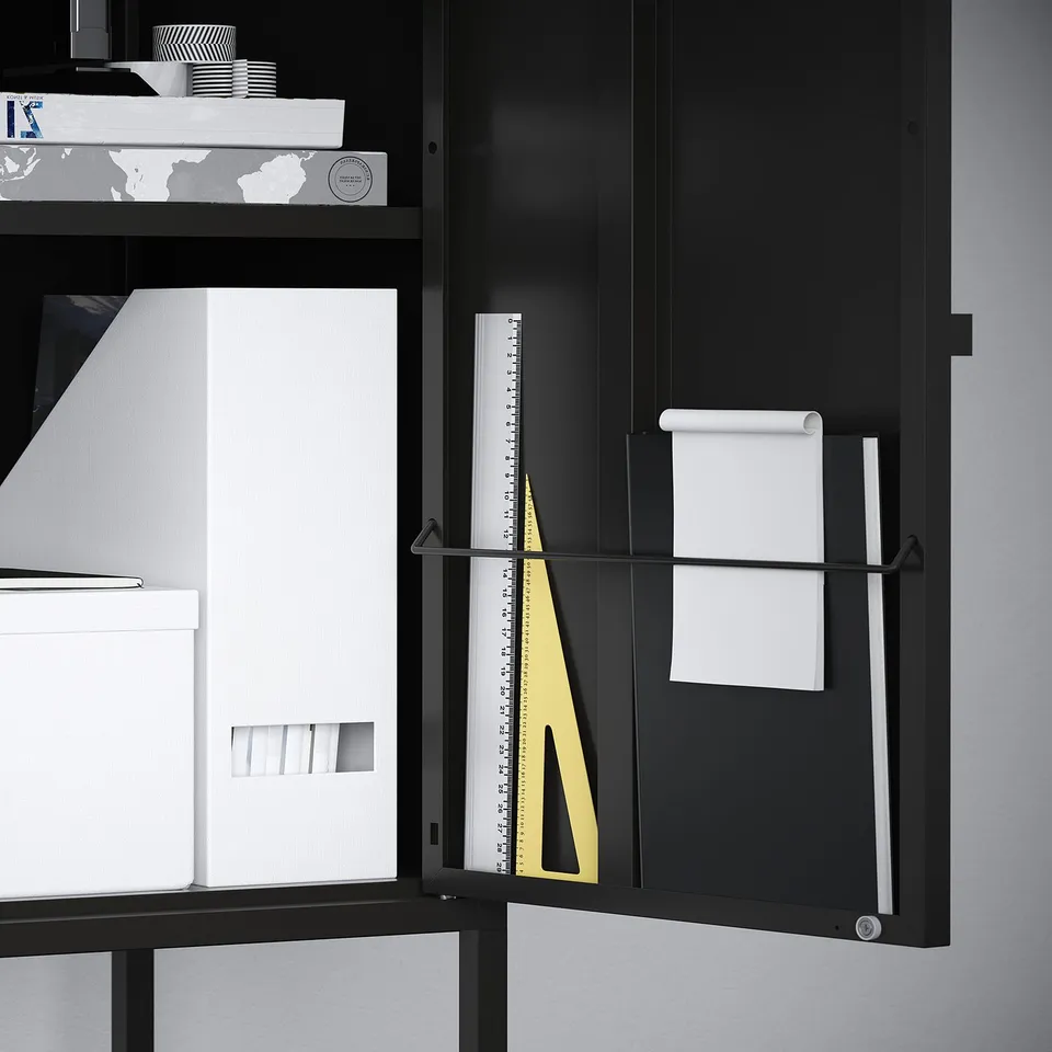 Black metal cabinet stores papers, letters, and charges; wall-mountable for safety.