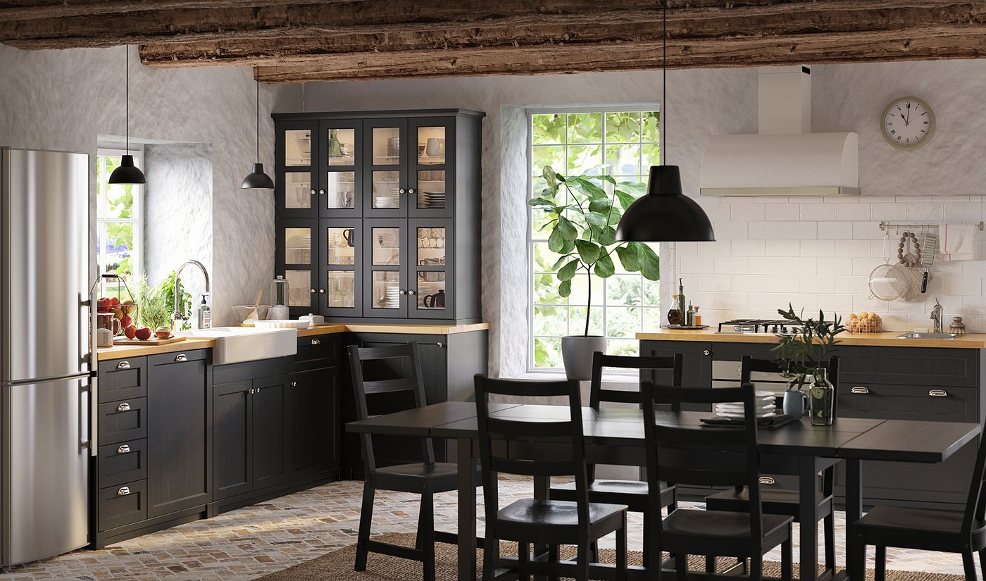 Modern kitchen with black METOD cabinets, wood countertops, stainless steel appliances, and hanging pendants. Large window and rustic beams.