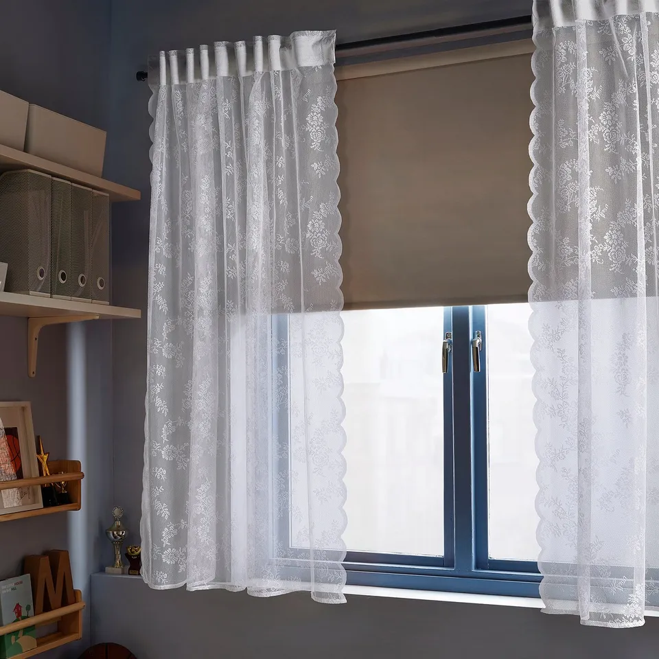 Lace curtains with flowery pattern & scalloped edges.