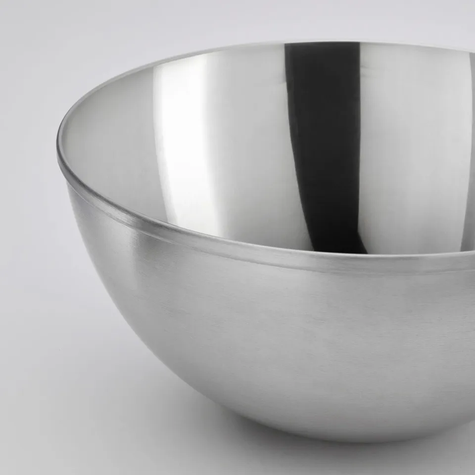 Stainless steel bowl, sleek and polished, reflecting light, simple design.