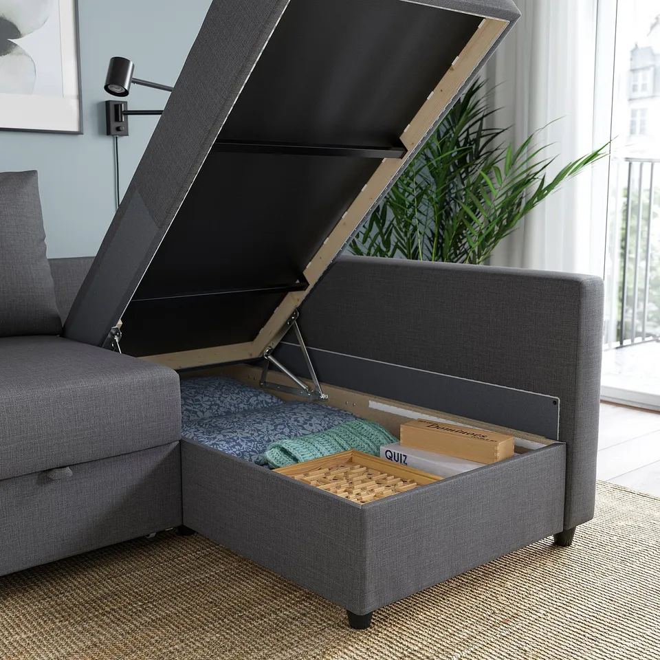 Multifunctional sofa with open storage compartment, showing boards and blanket inside.