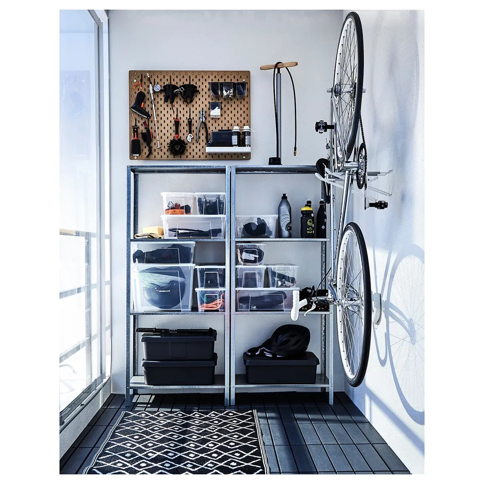 Organised shelving unit with clear and black storage bins for items. Bike hangs on wall.